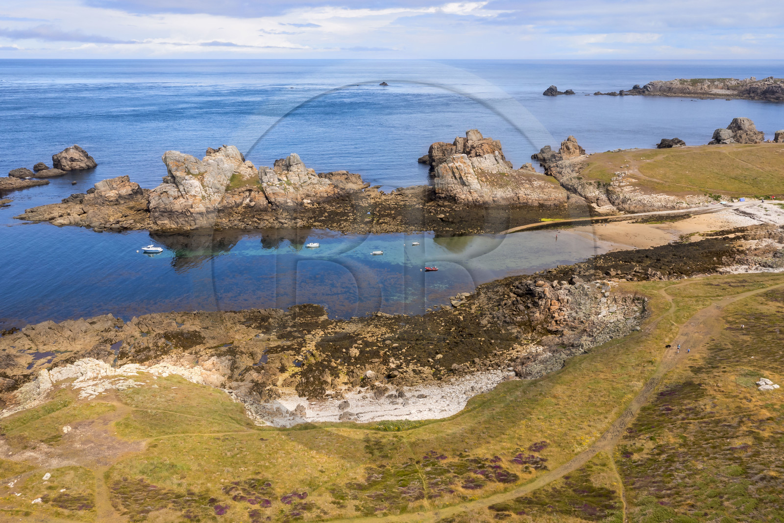 France, Finistère, Iroise Sea, Ouessant Island, hiker on the coastal path ahead the Yuzin beach and anchorage on the north coast (aerial view)