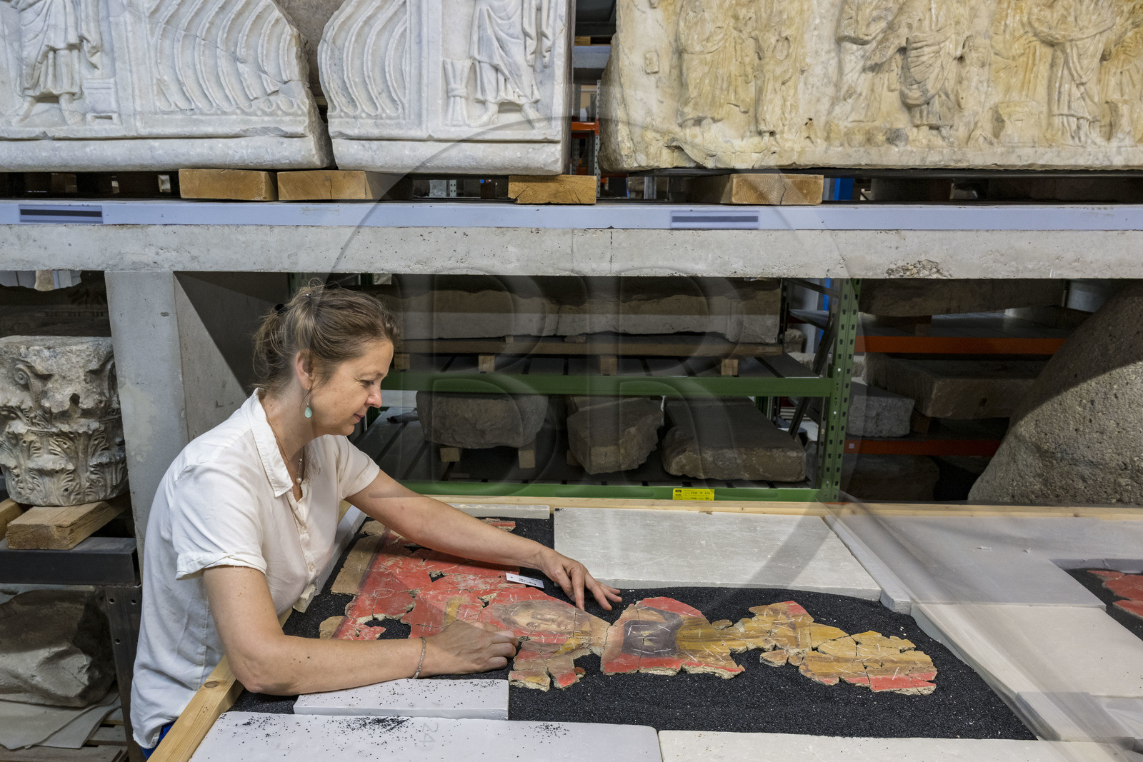 France, Bouches-du-Rhône (13), Arles, musée départemental Arles antique, dans les réserves du musée, issu des fouilles des ruines de la maison de la harpiste (entre 70 et 50 av. J.-C.) dans le site de l'ancienne verrerie de Trinquetaille sur la rive droite du Rhone, assemblage de fragments de la peinture murale à fresque adoptant du rouge vermillon avec le pigment le Cinabre le plus couteux du monde romain, la figure d’une harpiste qui a donnée son nom à la villa présentée par l'archéologue Marie-Pierre Rothé
