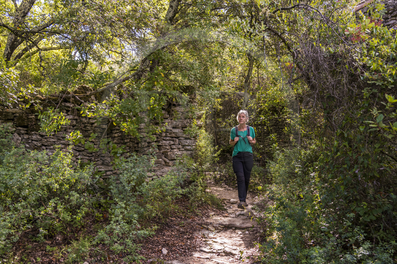 France, Gard (30), Uzès, randonneuse sur un chemin longeant dans la garrigue le tracé de l'aqueduc romain de Nimes