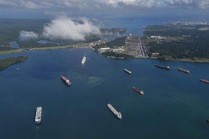 Panama, province de Colon, Canal de Panama, cargos sur le lac Gatun en attente de pouvoir franchir les écluses de Gatun, la baie Limon (Bahia Limon) coté Atlantique et la ville de Colon en arrière plan (vue aérienne)