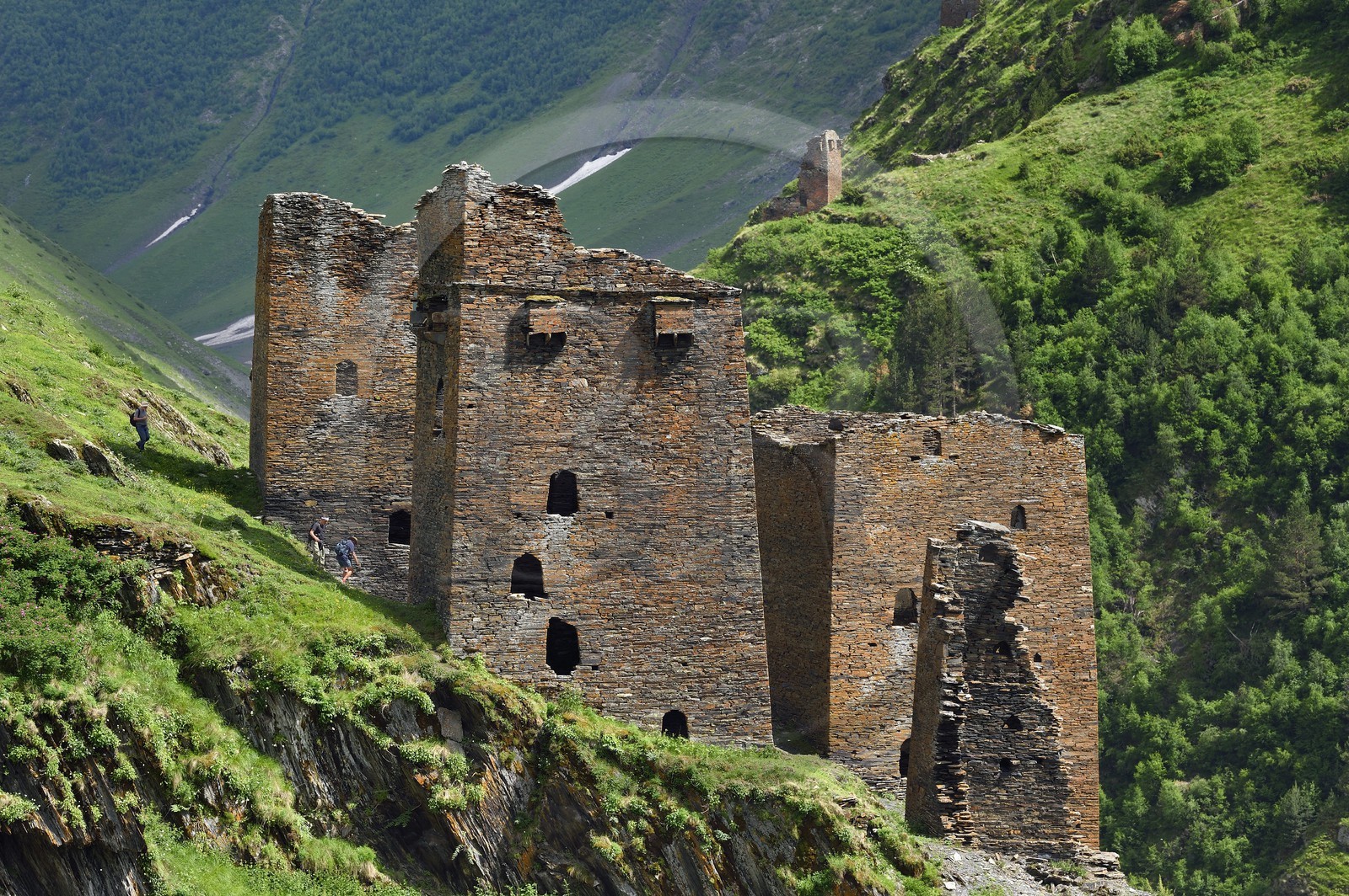 Georgia, Kakheti, Tusheti National Park, Alazani River Valley in the mountains of Pirikiti, hikers crossing a set of medieval defensive towers in the ancient village of Parsma (Baso)