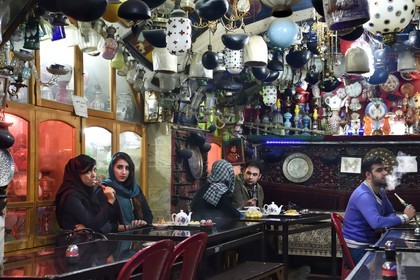 Iran, Isfahan Province, Isfahan, Chai Khaneh Azadegan Tea House and restaurant, man and woman smoking a water pipe