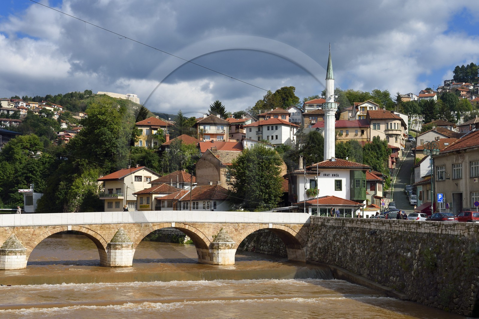 Bosnie-Herzégovine, Sarajevo, le pont Seher Cehaja sur la rivière Miljacka et la Maison du Défi à droite devant le minaret