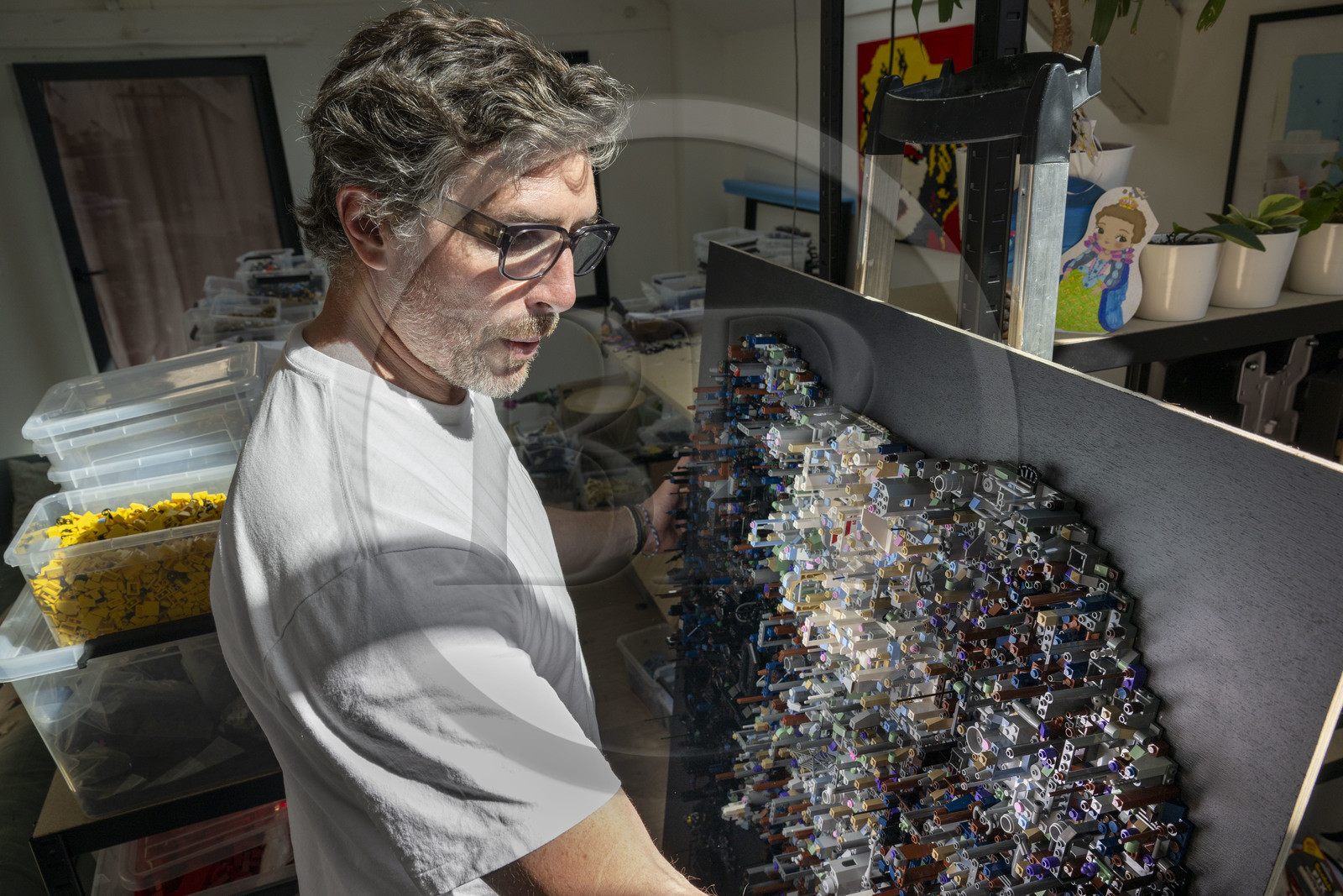 France, Cote d'Or, Dijon, Artist Aymeric Gillet, aka M'Brick, in his studio filled with crates of multicolored Lego used to create giant pixelated paintings inspired by pop culture