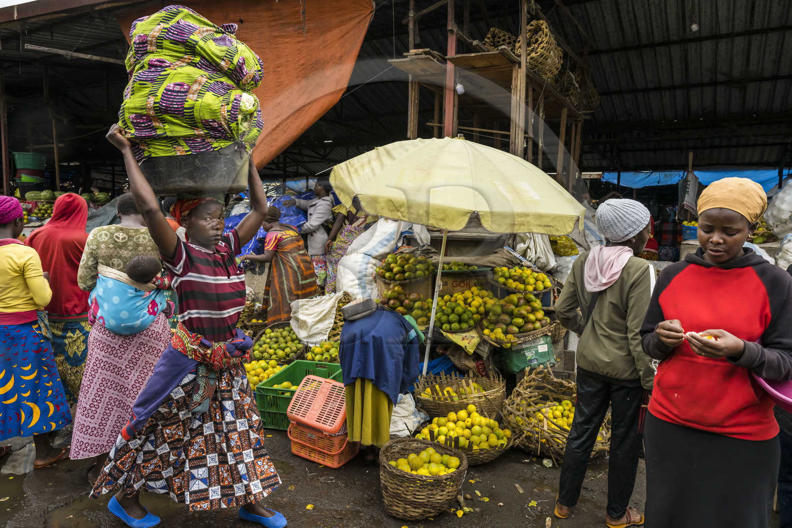 Rwanda, Northern Province, Musanze (formerly Ruhengeri), central Market, woman carrying a tray loaded with vegetables on her head