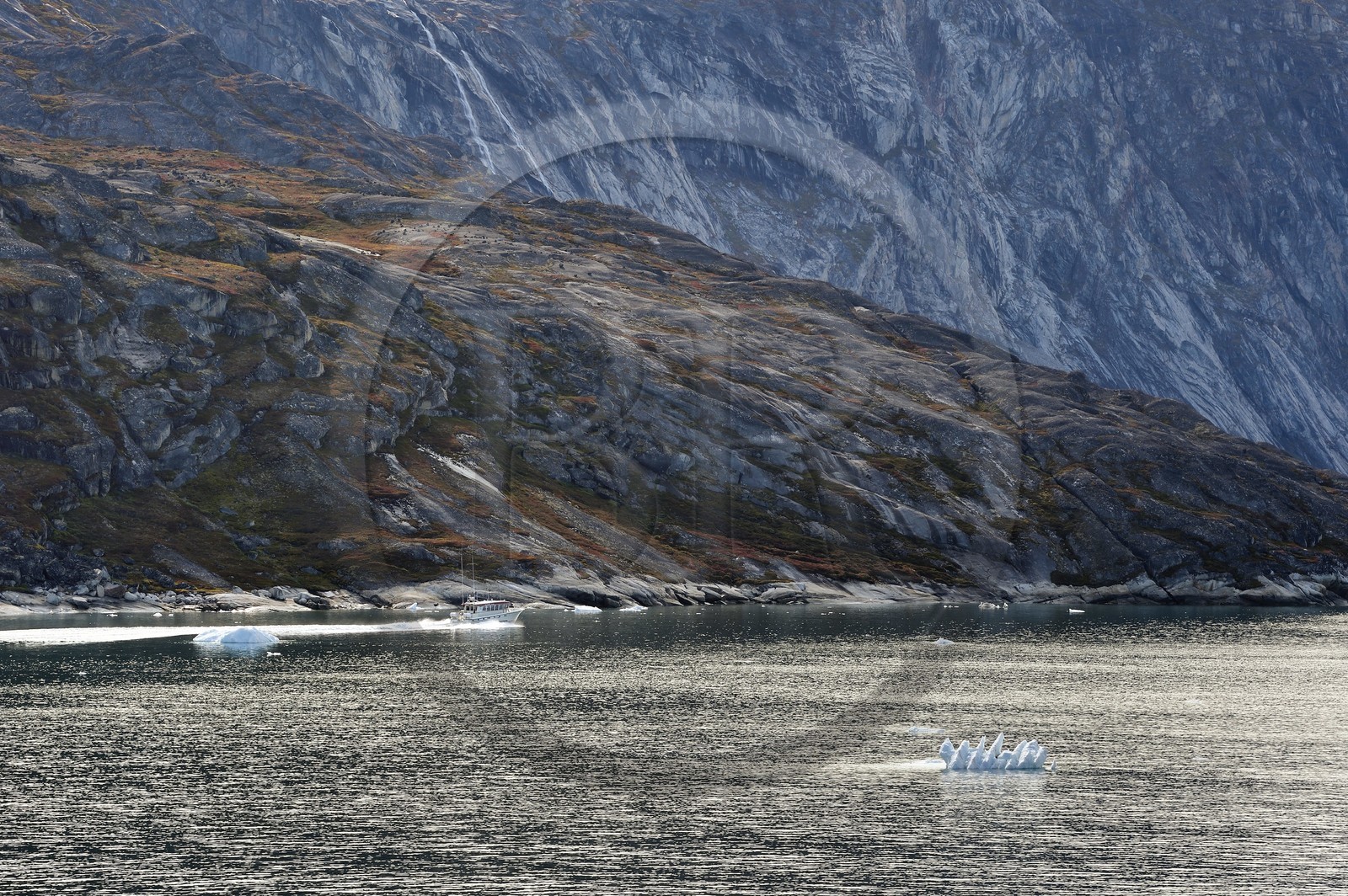 Greenland, west coast, Disko Bay, Ataa Strait, boat going up the strait of Ataa along the cliff