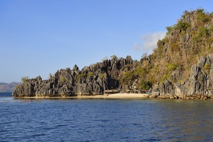 Philippines, Calamian Islands in northern Palawan, Coron Island Natural Biotic Area, Banul Beach under walls of limestone cliffs