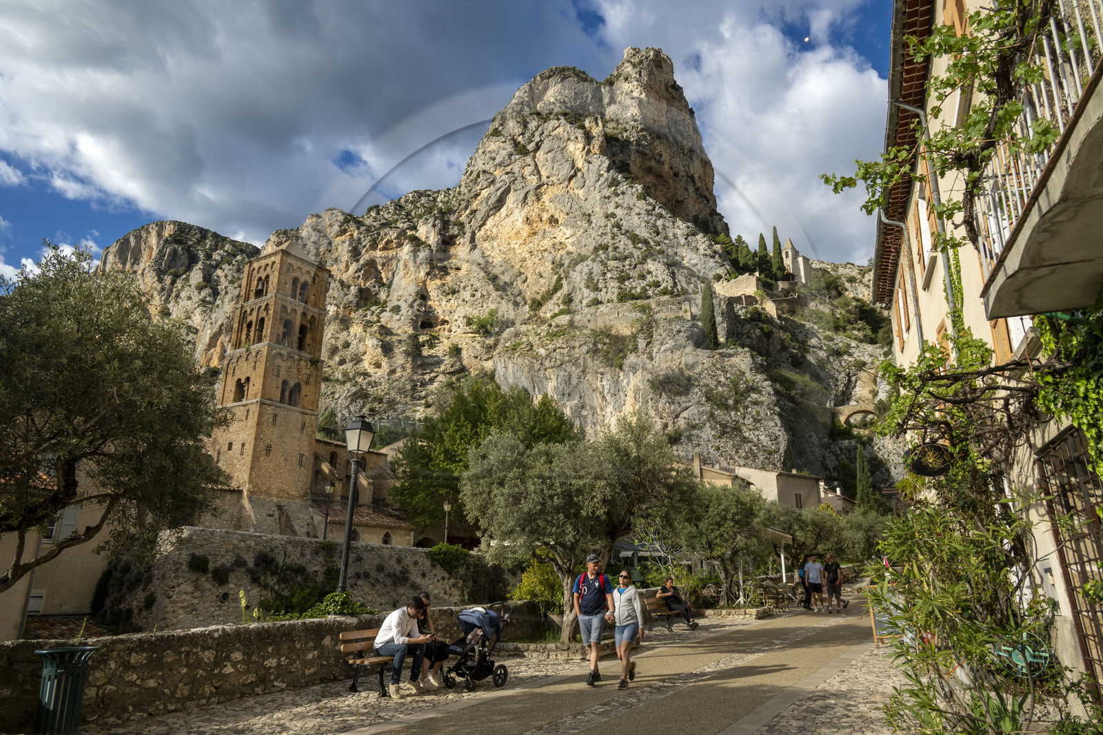 France, Alpes-de-Haute-Provence (04), Parc Naturel Régional du Verdon, Moustiers-Sainte-Marie, labellisé Les Plus Beaux Villages de France, l'église Notre-Dame-de-l'Assomption avec son clocher du XIIe siècle en tuff et la chapelle Notre-Dame de Beauvoir en arrière plan dans la falaise