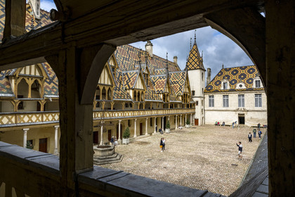 France, Côte-d'Or (21), Beaune, zone classée Patrimoine Mondial de l'UNESCO, Hospices de Beaune, l'Hôtel-Dieu, toiture en tuiles vernissées multicolores protegeant la longue galerie à arcades dans la cour d'honneur