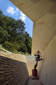 France, Dordogne (24), Montignac, chantier du futur Centre International de l'Art pariétal de Montignac-Lascaux (Lascaux 4) conçu par l'agence norvégienne d'architecture Snøhetta, chemin d'accès à la reconstitution de la grotte par une longue tranchée en pente en lisière de forêt et faite de béton et de pierres du pays