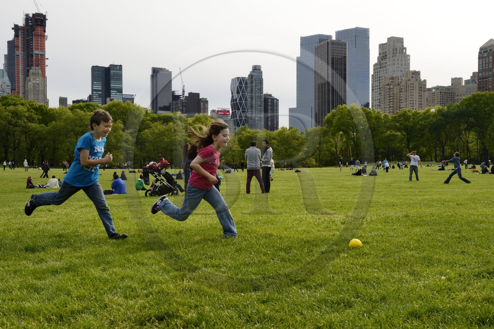 Etats-Unis, New York, Manhattan, Central Park, enfants jouant au football sur le Sheep Meadow, immeubles de Central Park Sud en arrière plan