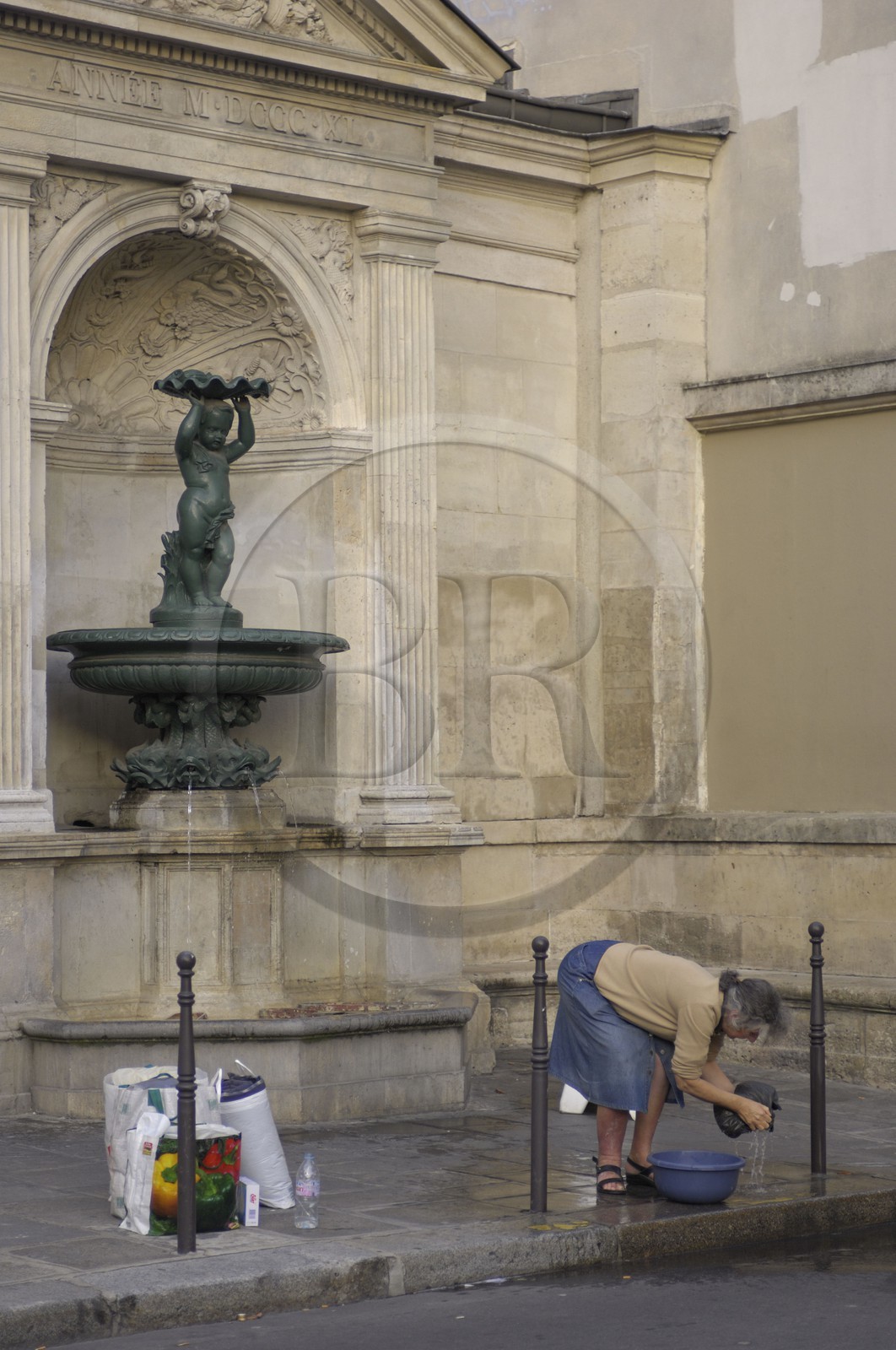 France, Paris (75), dame nettoyant son linge à la fontaine jouxtant le Lycée Charlemagne