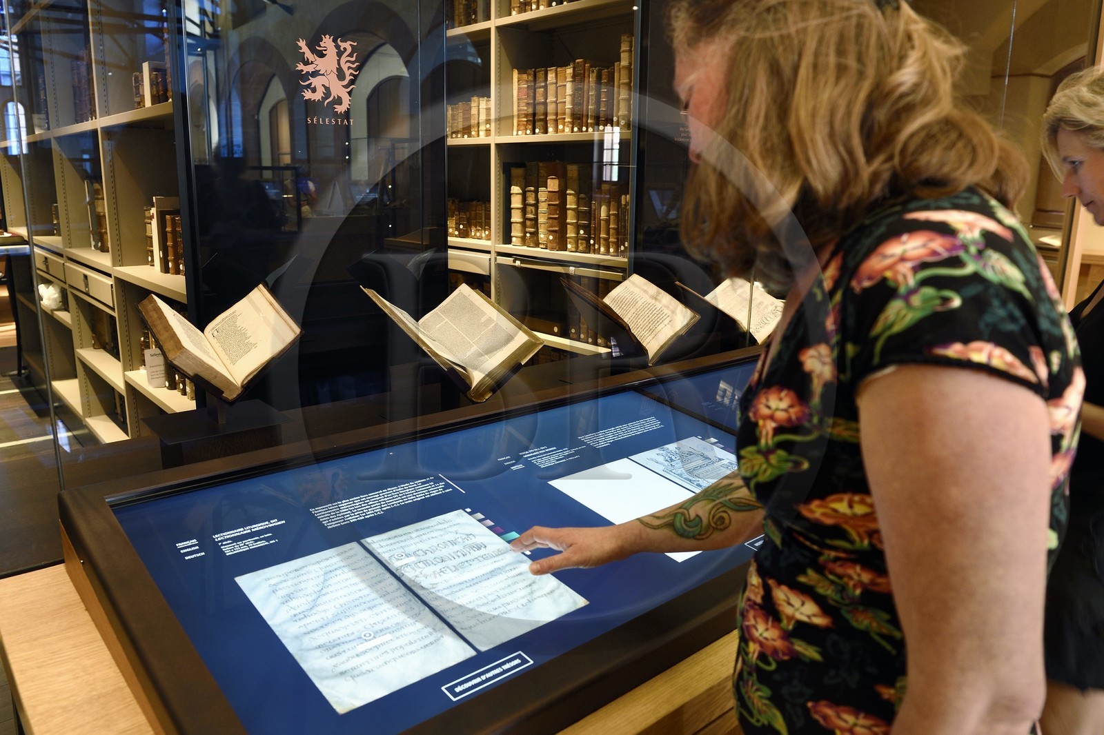 France, Bas-Rhin (67), Selestat, la Bibliothèque humaniste réaménagée par l'architecte Rudy Ricciotti, lecture en numérique du livre Lectionnaire liturgique dit Lectionnaire Mérovingien, manuscrit sur parchemin en latin (7ème siècle), la bibliothèque personnelle de Beatus Rhenanus (1485-1547) est en arrière plan dans la pièce vitrée
