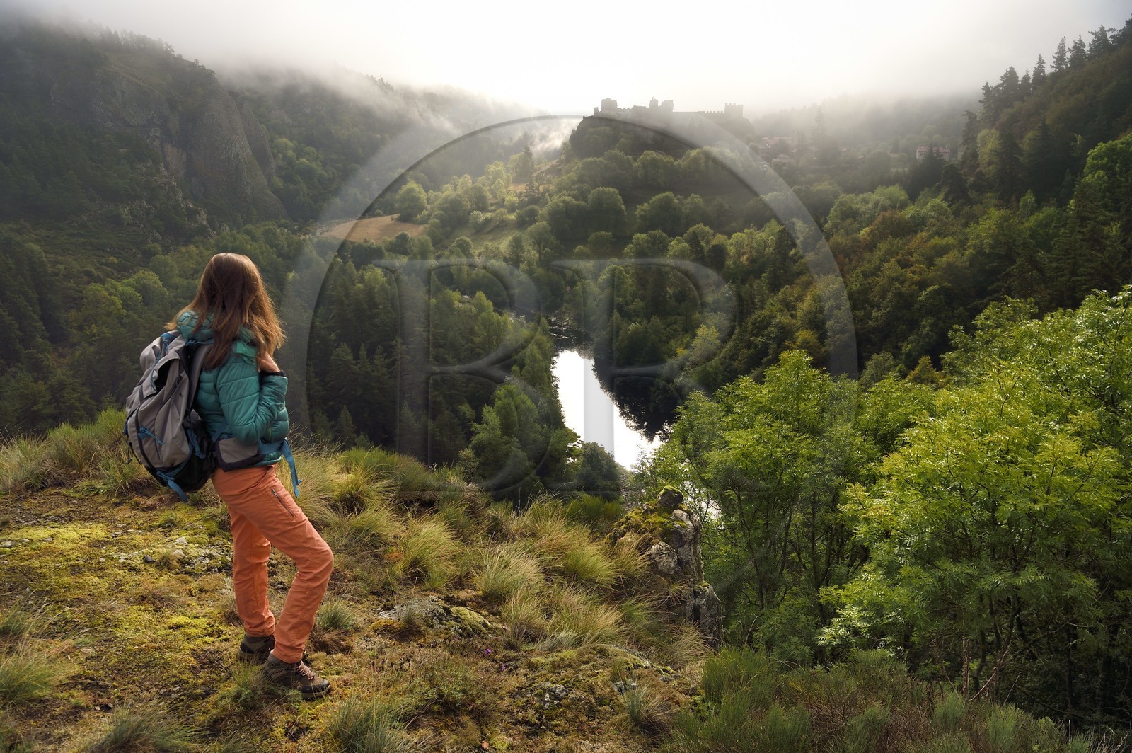 France, Haute-Loire (43), vallée de la Loire, Arlempdes, labellisé les Plus beaux villages de France, randonneuse observant les ruines du chateau perché sur un rocher basaltique qui surplombe un méandre de la Loire