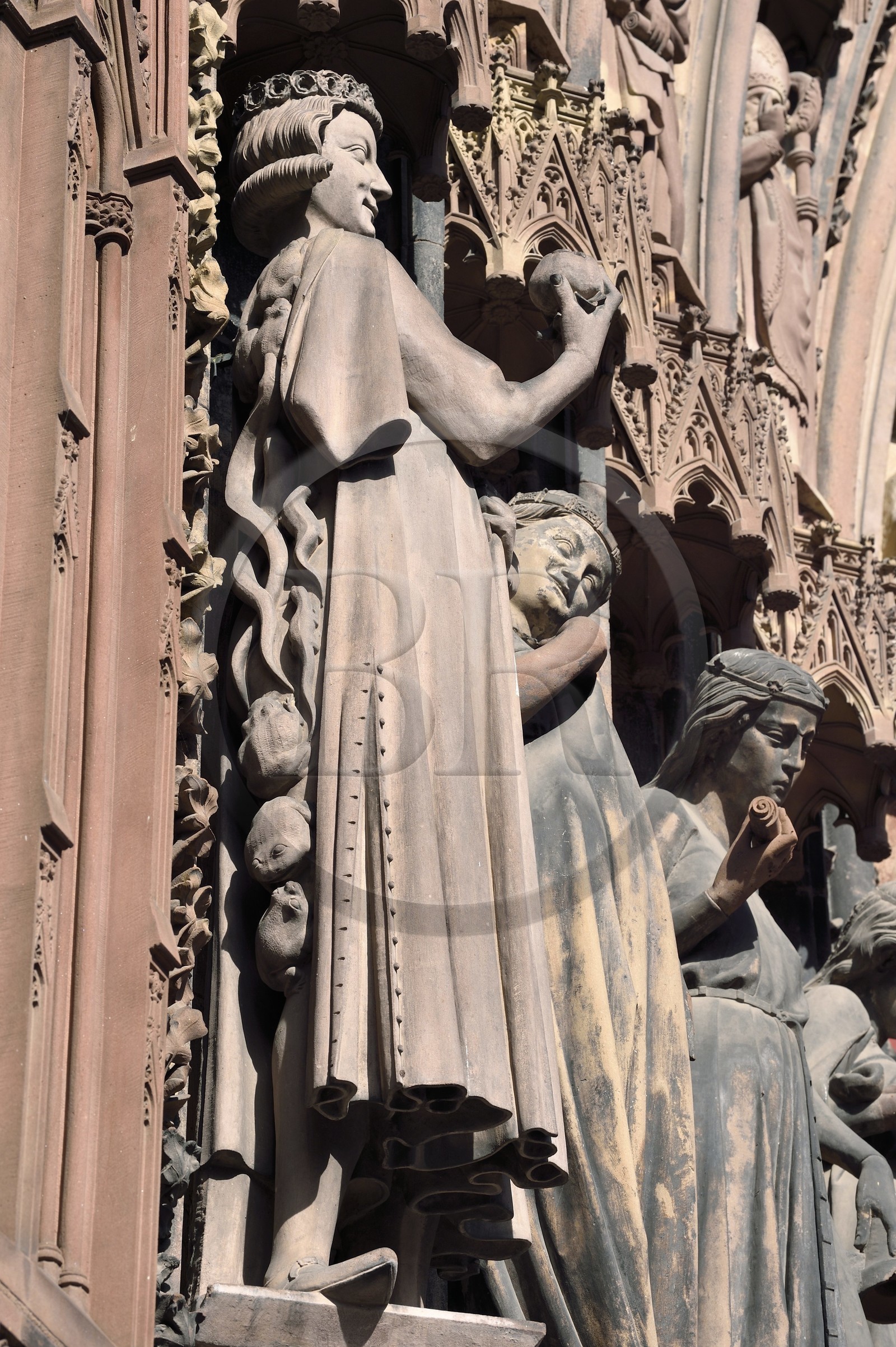 France, Bas-Rhin (67), Strasbourg, vieille ville classée au Patrimoine Mondial de l'UNESCO, la cathédrale Notre-Dame, la facade occidentale, portail latéral sud (fin du XIIIème siècle), Vierges folles séduites par le Tentateur, élégant jeune homme habillé à la mode du temps, qui présente la pomme avec assurance mais masque mal son dos envahi de batraciens et serpents