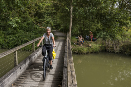 France, Charente-Maritime (17), Saint-Agnan, cycliste sur la véloroute en direction de l'abbaye de Trizay, rencontre avec des pêcheurs en bordure du petit canal de Pont-l'Abbé dans la vallée de l’Arnoult