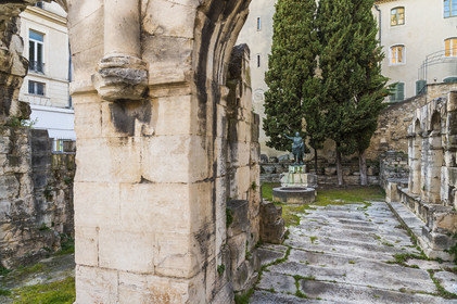 France, Gard, Nimes, Augustus Gate, entrance to the Domitian Way in the city and the reproduction of a statue of the Emperor Augustus in the background