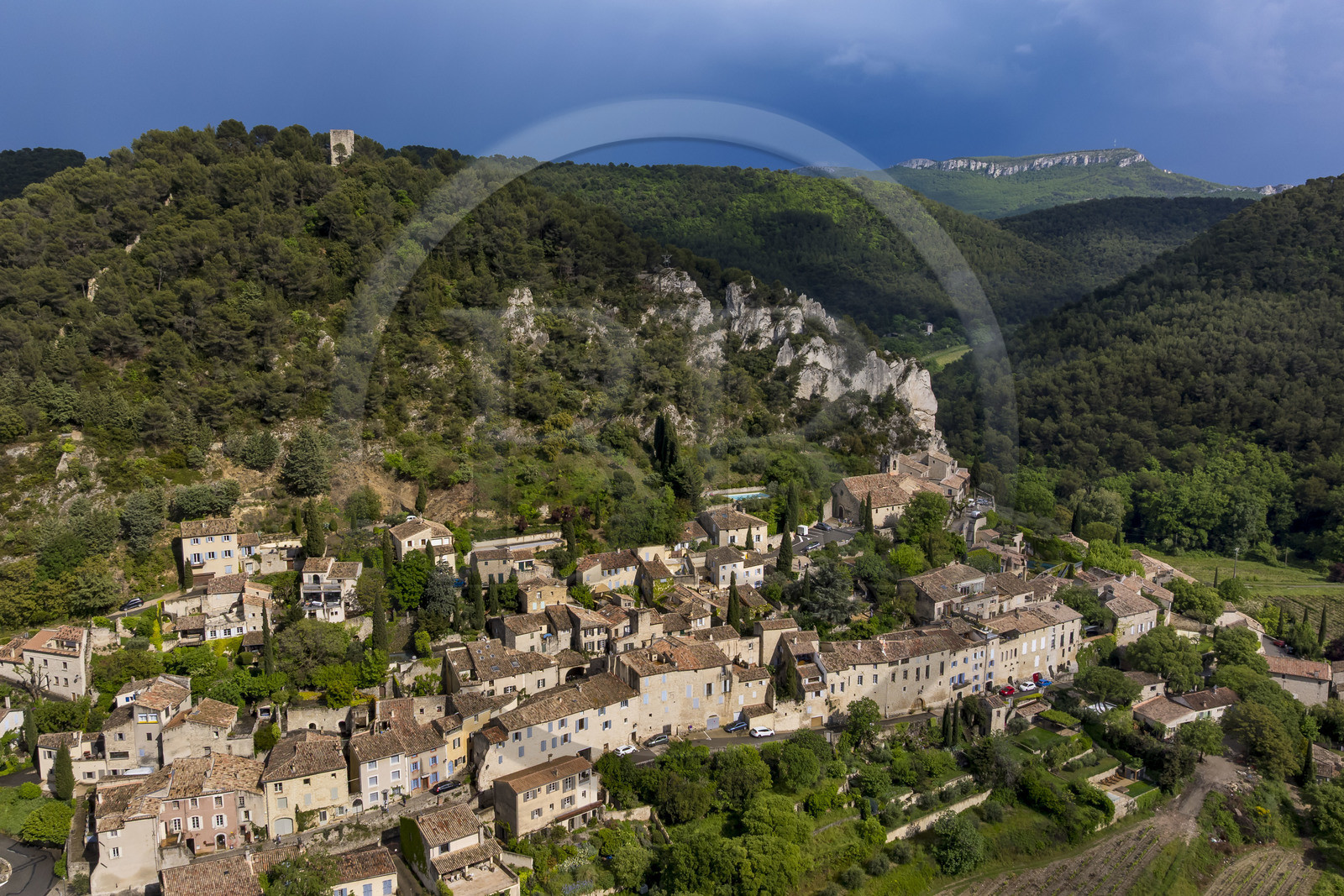 France, Vaucluse, Dentelles de Montmirail mountains, the medieval village of Séguret, labelled Les Plus Beaux Villages de France (The Most Beautiful Villages of France), on a stormy day and the Saint-Amand ridge seen from the south in the background (aerial view)