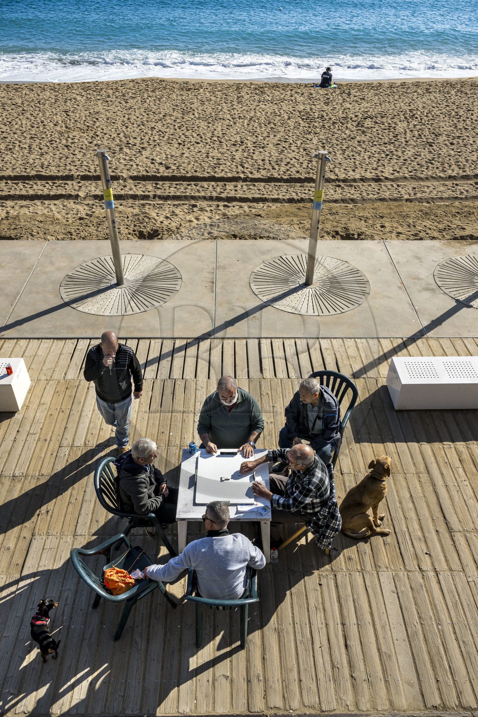 Spain, Catalonia, Barcelona, La Barceloneta, domino players on the beach