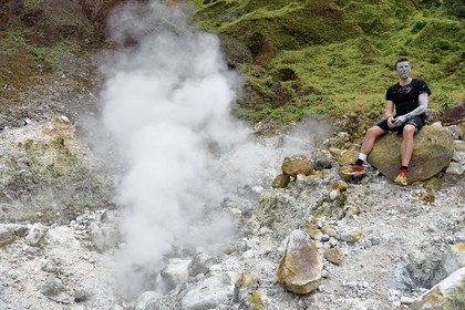 Caraïbes, Ile de la Dominique, Castle Bruce, Parc national du Morne Trois Pitons classé Patrimoine Mondial de l'UNESCO, la Vallée de la Désolation, randonneur sur le sentier menant au Boiling Lake avec un masque d'argile pur de la une rivière aux sources d'eau chaude dont la couleur unique est due à la présence de calcium, de carbone, de soufre et de fer
