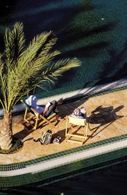 Tunisie, sud tunisien, Oasis de Ksar Ghilane, repos au bord de la piscine de l' hôtel Ksar Ghilane