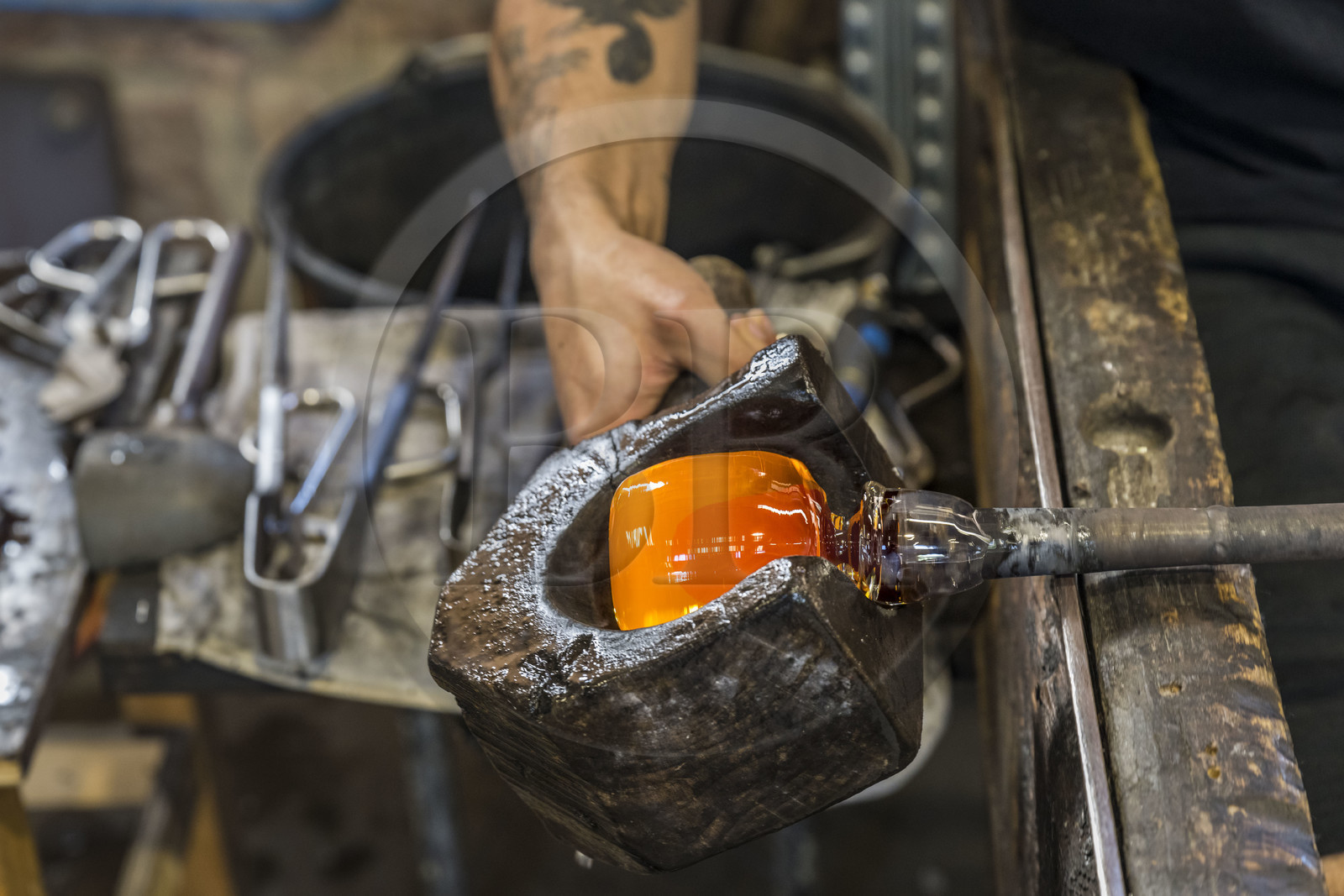 France, Moselle (57), Meisenthal, Centre international d’Art verrier (CIAV), l'atelier de soufflage, le souffleur régularise la masse au marbre tout en effectuant une rotation continue de sa canne et préparation de la paraison avant le passage au moule
