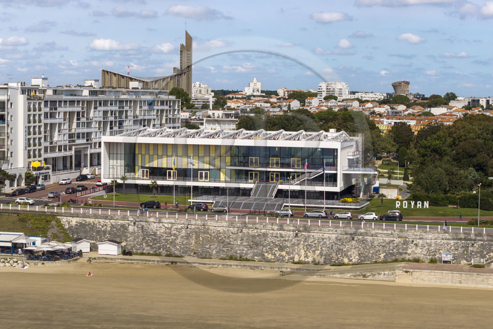 France, Charente-Maritime (17), Royan, le Palais de congrès (1957) signé de l’architecte-urbaniste Claude Ferret et rythmés par les panneaux perforés en aluminium jaune et gris des ateliers Jean Prouvé en façade, l'église Notre-Dame de Royan construite de 1955 à 1958 par l'architecte Guillaume Gillet en arrière plan (vue aérienne)