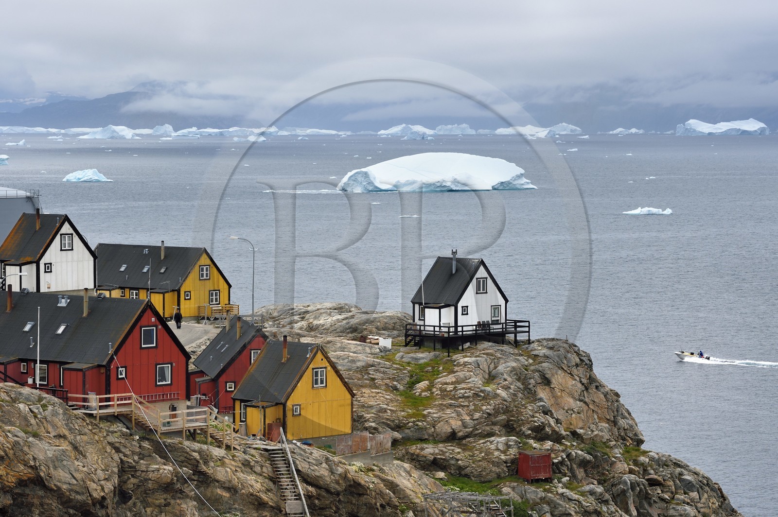 Groenland, cote ouest, baie de Baffin, la ville de Uummannaq accrochée à la roche et icebergs en arrière plan
