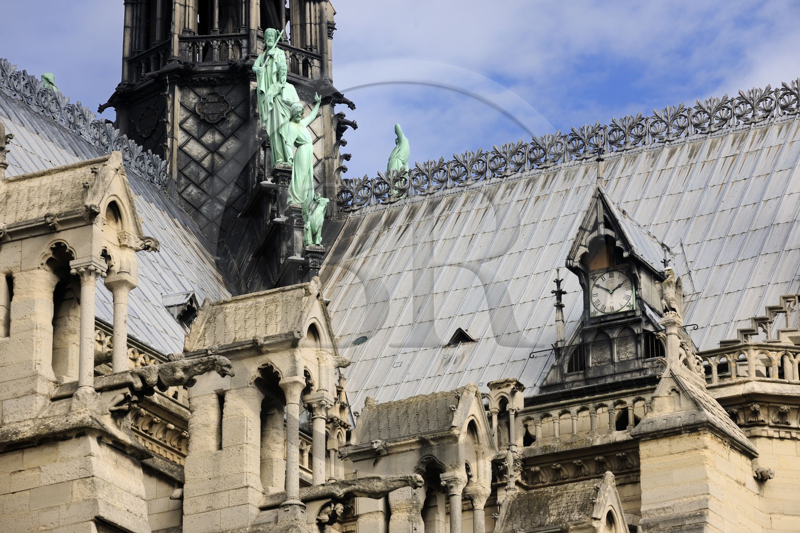 France, Paris (75), île de la Cité, la cathédrale Notre-Dame, une des horloges et la flèche domine les statues de cuivre vert-de-grisé des douze apôtres avec les symboles des quatre évangélistes