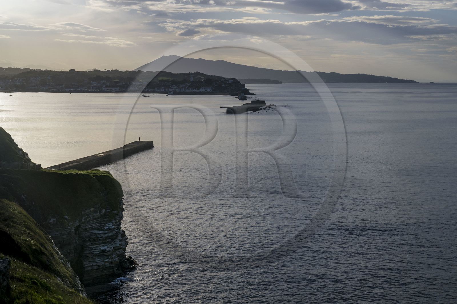 France, Pyrenees Atlantiques, Basque Country coast, Saint-Jean-de-Luz, fisherman on the Sainte-Barbe dike at the entrance to the bay of Saint-Jean-de-Luz and the Spanish mount Jaizkibel in the background (aerial view)
