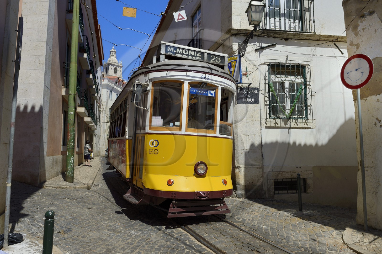 Portugal, Lisbon, Alfama district, tram (electricos) along Rua das Escolas Gerais with the tower of Sao Vicente de Fora church