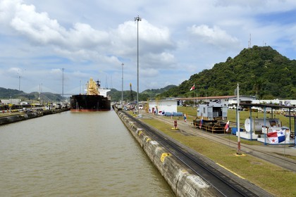 Panama, Canal de Panama, écluses de Pedro Miguel, mules mécaniques ou locomotives électriques guidant un cargo Panamax entre les murs de l'écluse
