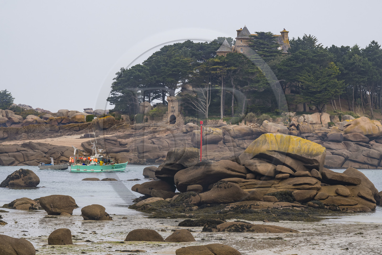 France, Côtes-d'Armor (22), Côte de Granit Rose, Perros-Guirec, bateau de pêche dans le chenal de sortie du port naturel de Ploumanac'h et le chateau de Costaérès sur son ile en arrière plan