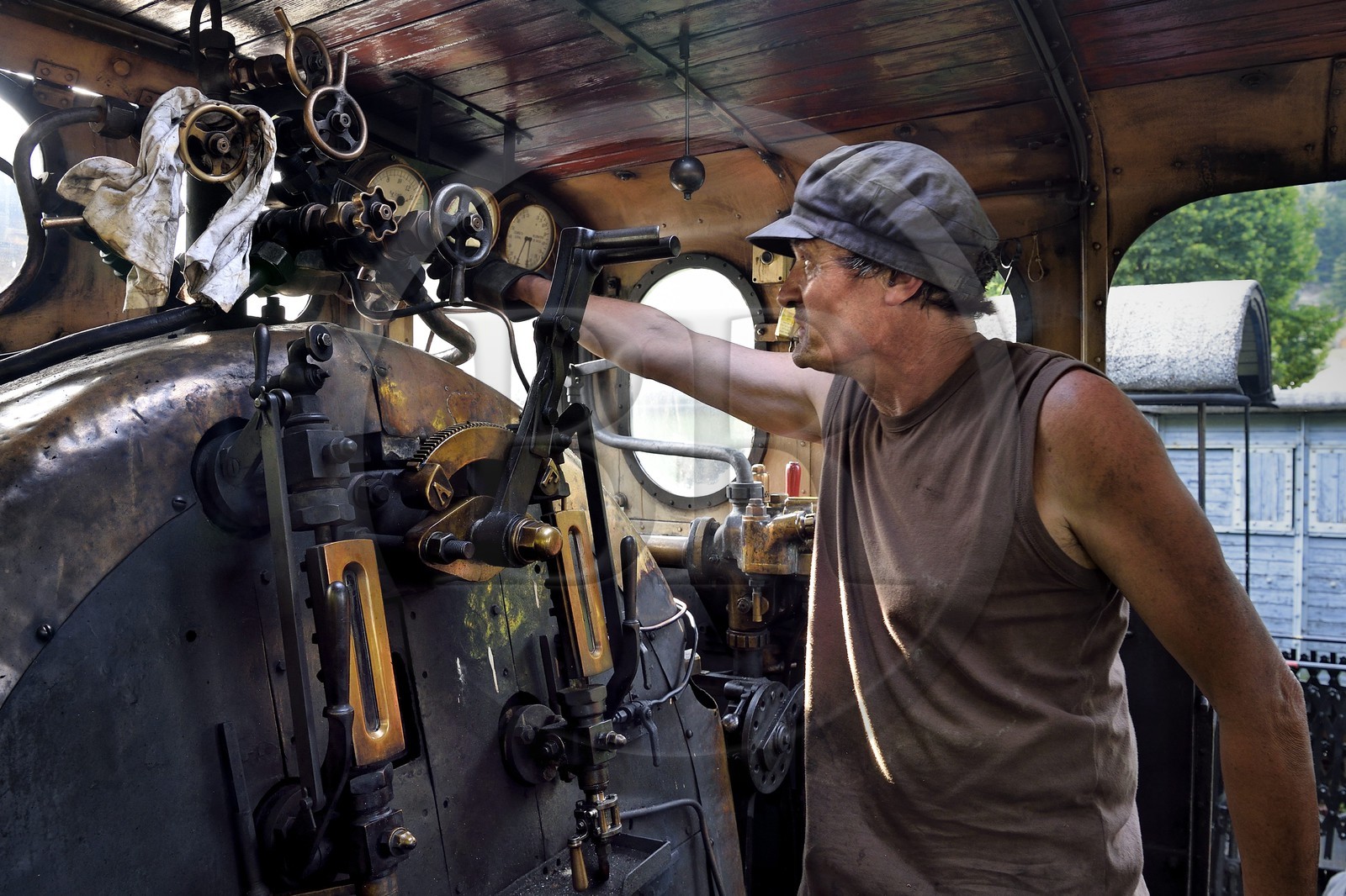 France, Alpes-Maritimes (06), Puget Théniers, locomotive en chauffe, dans la cabine, Frederic Laugier bénévole du G.E.C.P. qui restaure et exploite le Train des Pignes, aujourd'hui chauffeur