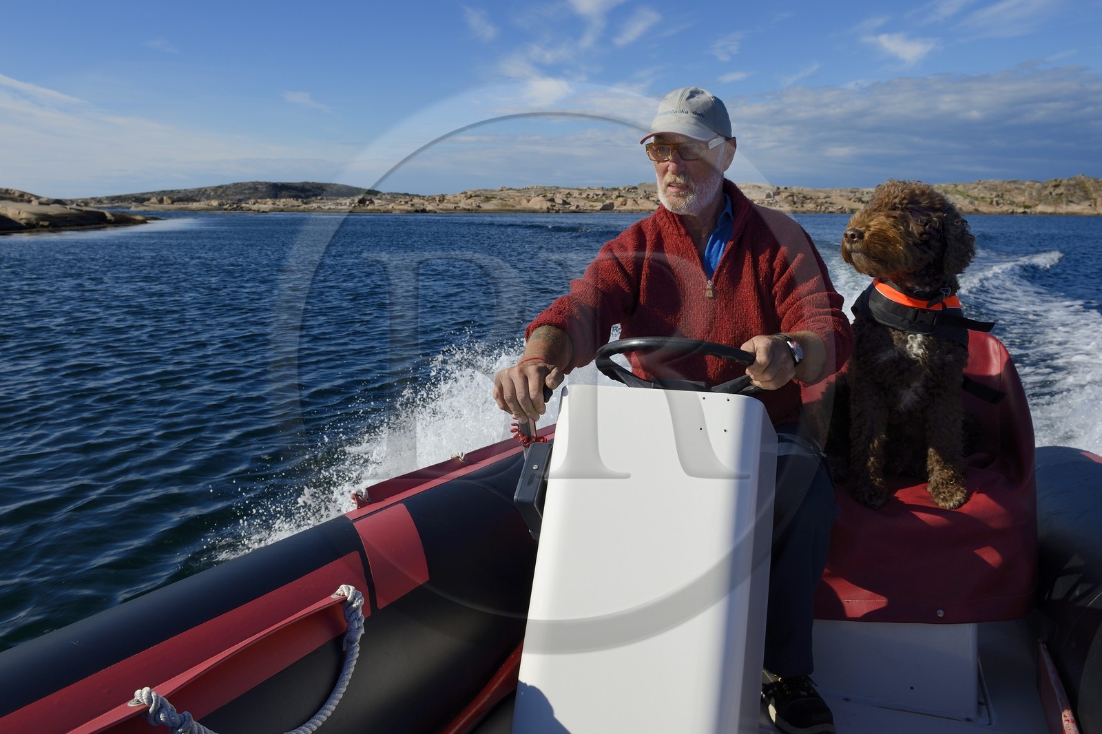 Sweden, Västra Götaland, Smögen, Cyril and his dog Simpson aboard his zodiac