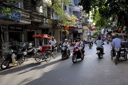 Vietnam, Hanoï, circulation de motos et cyclo pousses dans la vieille ville