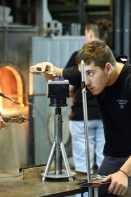 France, Moselle (57), Meisenthal, Centre international d’Art verrier (CIAV), l'atelier de soufflage, fabrication artisanale d'une boule de Noël, pose de la pastille pour la création du crochet en verre
