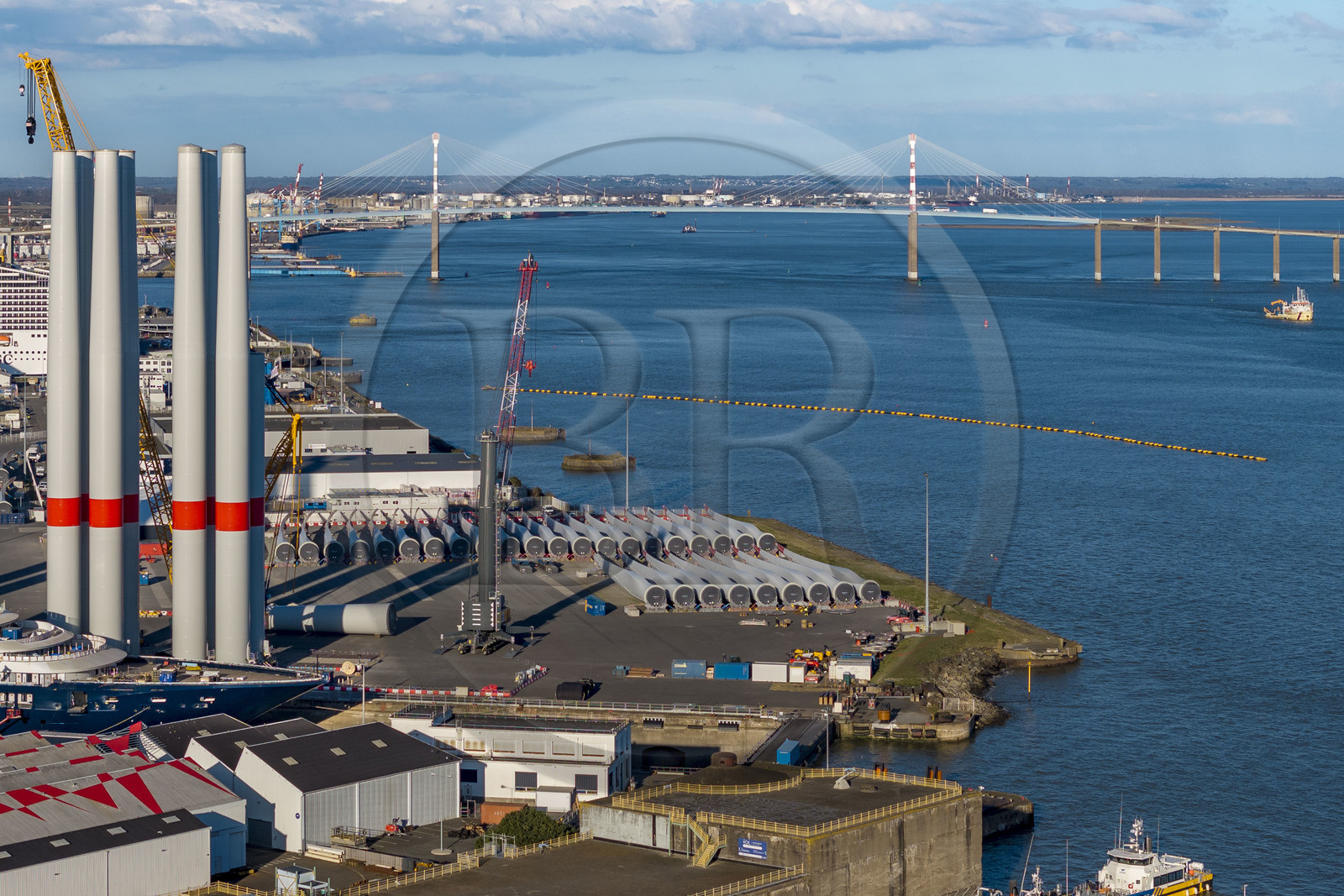 France, Loire Atlantique, the wind turbine towers are stored before embarkation, the Saint-Nazaire bridge in the background (aerial view)