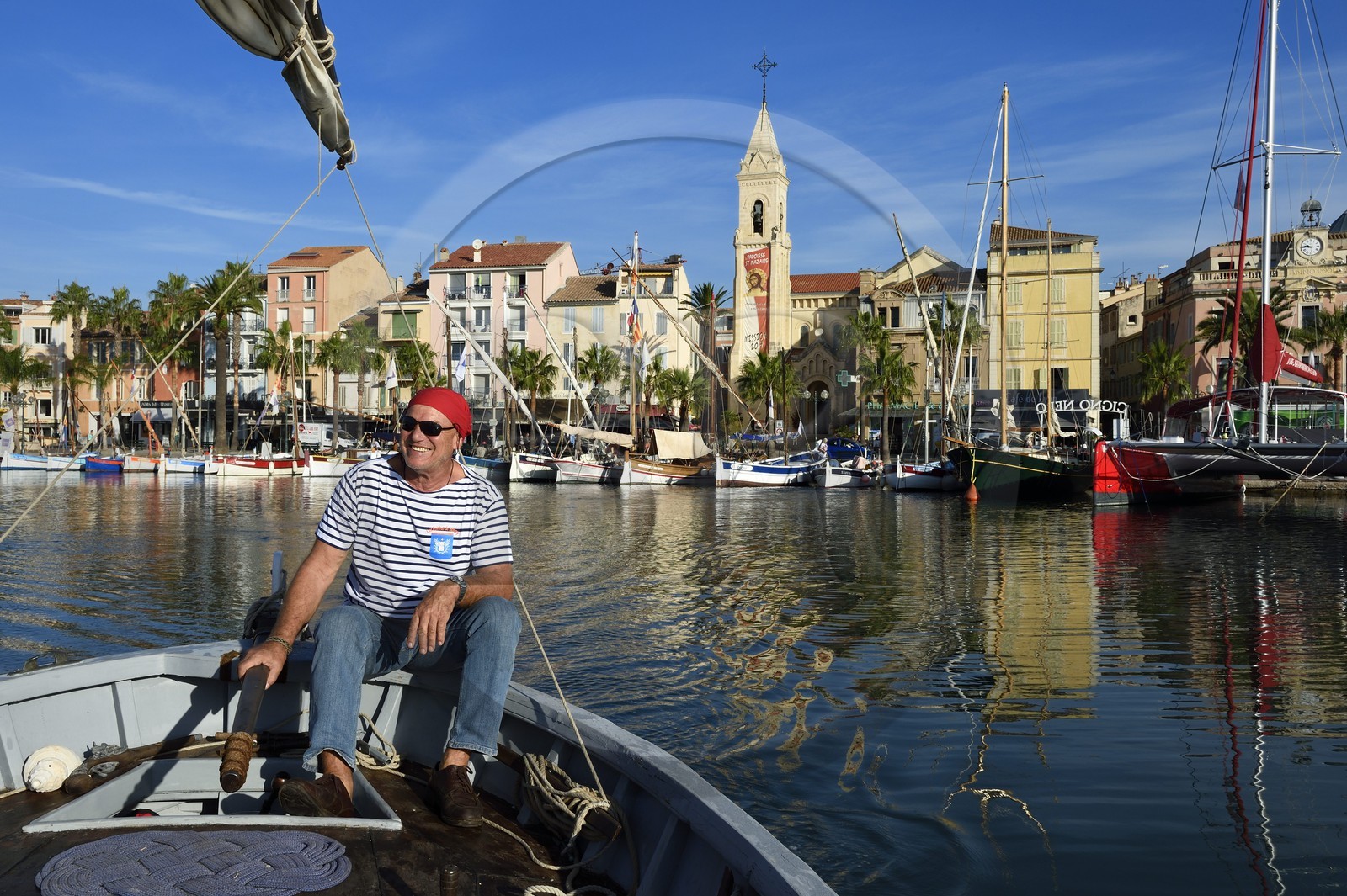 France, Var, Sanary-sur-Mer, traditional fishing boats called pointus in the port and St. Nazaire Church, Christian Benet who is president of the Sanary Pointus association