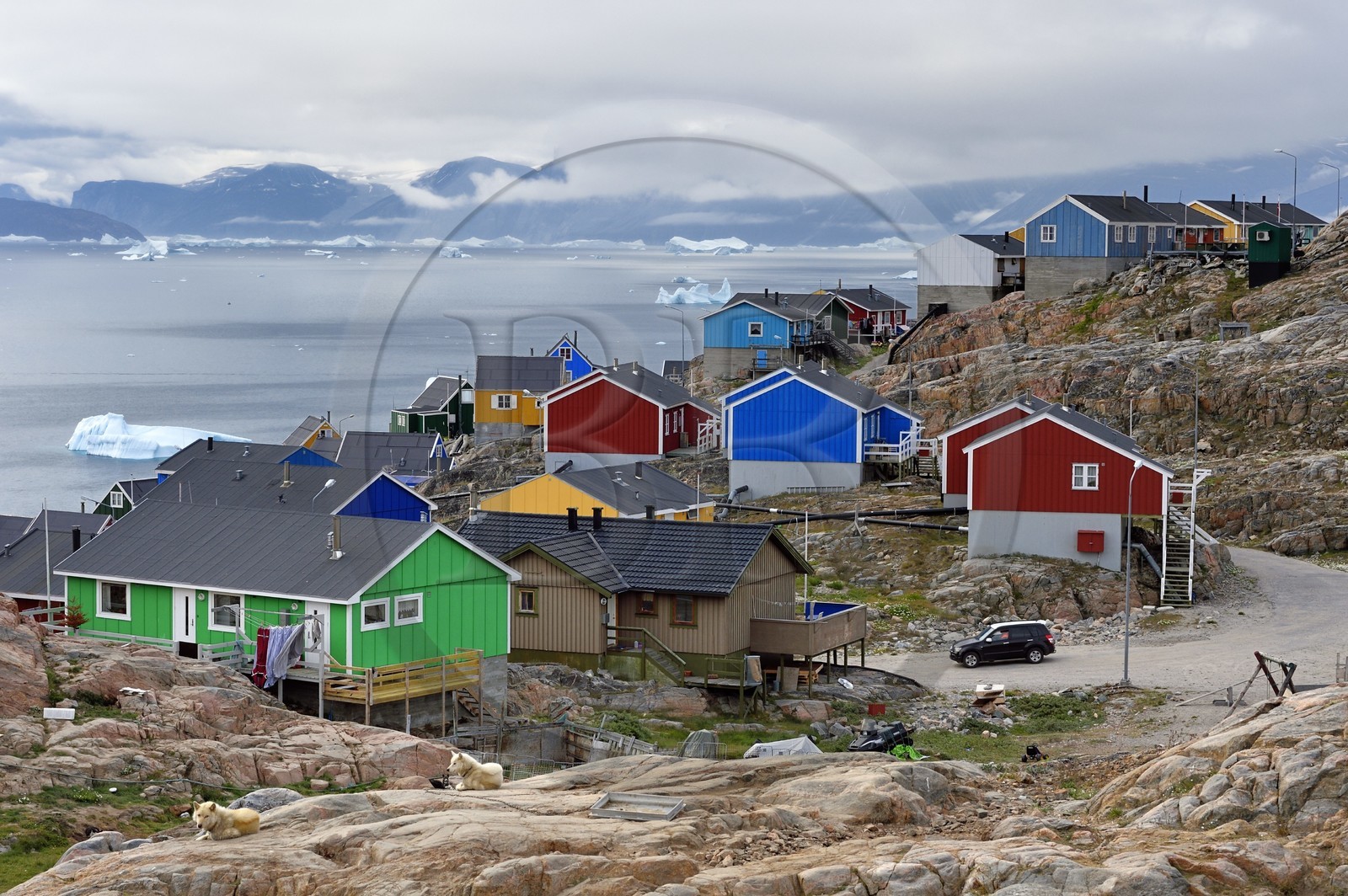 Groenland, cote ouest, baie de Baffin, la ville de Uummannaq accrochée à la roche et icebergs en arrière plan