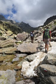 France, Alpes-Maritimes, parc national du Mercantour (Mercantour National Park), the Vallee des Merveilles (Valley of Wonders) scattered with thousands of rupestral engravings of the Bronze Age, hikers on the trail GR 52 towards the Baisse (pass) de Valmasque and the Mont Grand Capelet (2915 m) in the background