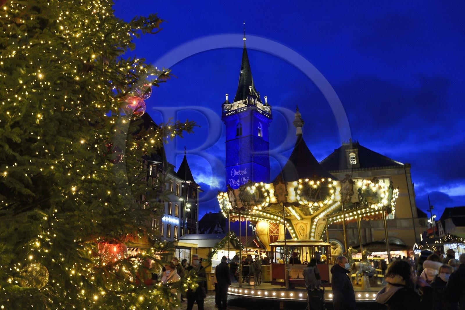 France, Bas Rhin, Obernai, Christmas market on the market square, Chapel Tower (Kappelturm) completed in the 16th century, serves as a belfry next to the town hall