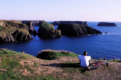 France, Morbihan (56), Belle-Île, un cycliste admirant le chaos rocheux de Port Goulphar