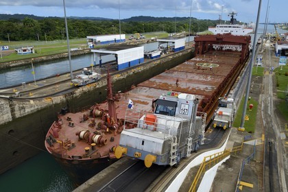 Panama, province de Colon, Canal de Panama, écluses de Gatun, mules mécaniques ou locomotives électriques guidant un cargo Panamax entre les murs de l'écluse