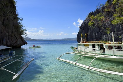 Philippines, Calamian Islands dans le nord de Palawan, Coron Island Natural Biotic Area, pirogue à balancier au pied des rochers de calcaire dans une petite crique