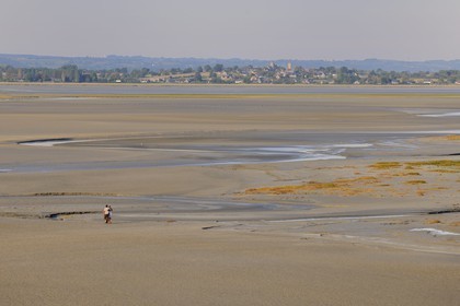 France, Manche, crossing by walking of the Bay of Mont Saint Michel at low tide and the village of Saint Leonard