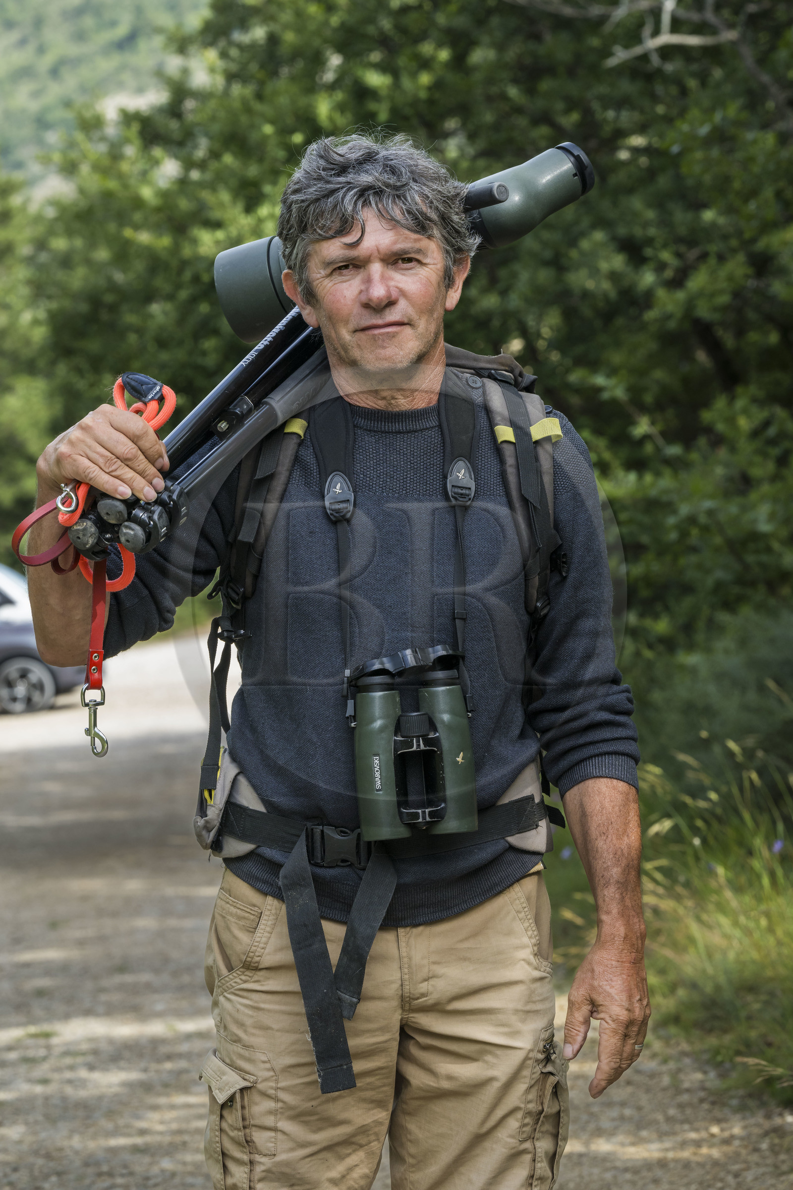 France, Drome, regional natural park of Baronnies provencales, Remuzat, Christian Tessier, director of the Vautours en Baronnies association, goes to observe griffon vultures on the Saint-Laurent plateau with a telescope over his shoulder