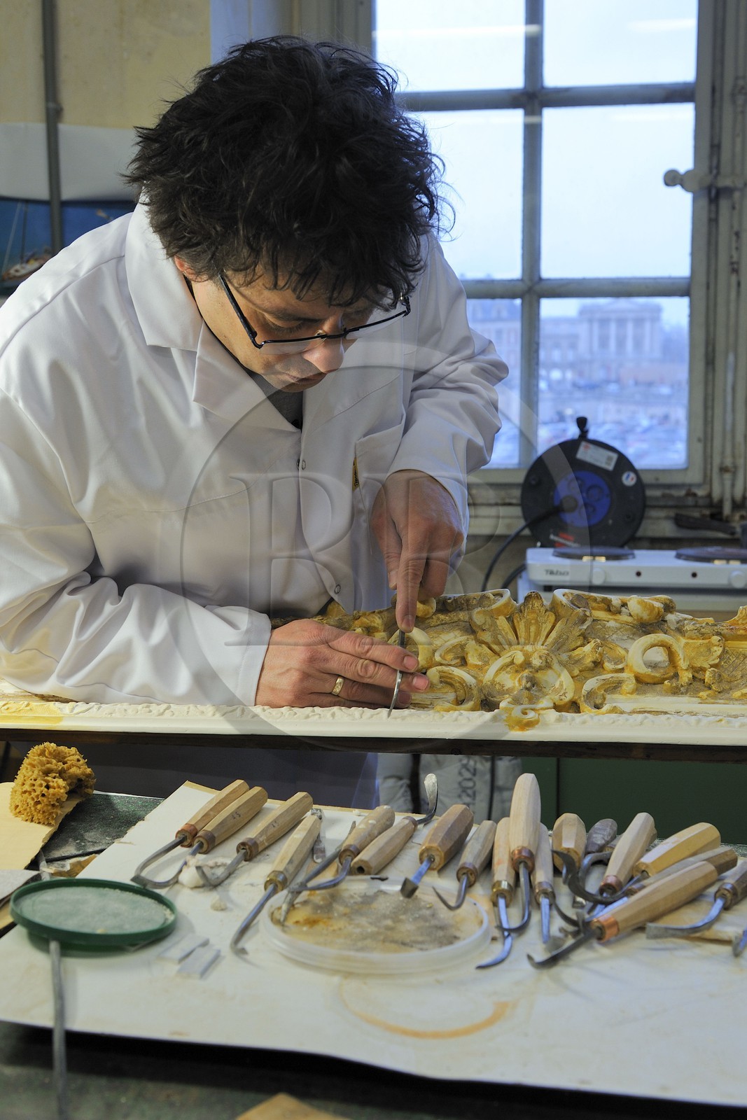 France, Yvelines (78), château de Versailles, ateliers de restauration du château, atelier de dorures, Laurent Hissier travaillant sur un cadre de tableau