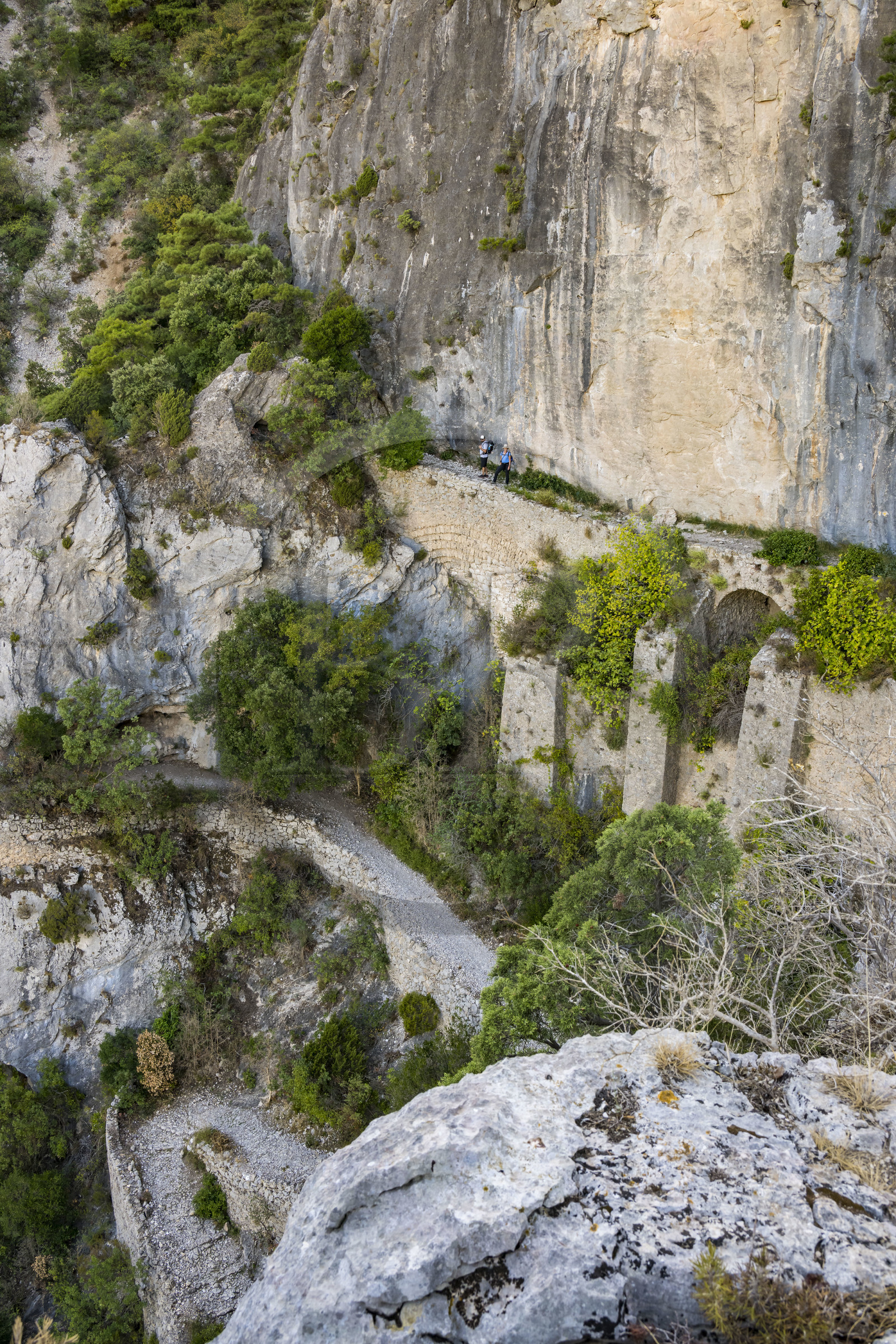 France, Hérault (34), Causses et les Cévennes, paysage culturel de l'agro-pastoralisme méditerranéen, classés Patrimoine Mondial de l'UNESCO, Saint-Guilhem-le-Désert, labellisé Les Plus Beaux Villages de France, randonneurs sur la Via Tolosana sur le Chemin de Saint-Jacques-de-Compostelle, le passage des Fenestrelles aménagé au Moyen-age par les moines de l'abbaye afin de franchir ce verrou rocheux dans le cirque de l'Infernet