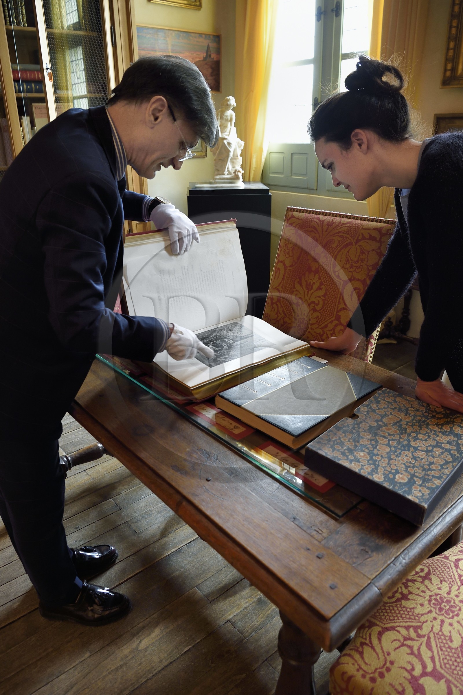 France, Aisne (02), Château-Thierry, Musée Jean de La Fontaine - Ville de Chateau-Thierry, le directeur du pole muséal Nicolas Rousseau et sa directrice adjointe Marie-Mileva Pavlovitch observant le livre des Fables de La Fontaine, édition illustrée (1867, in-folio) par Gustave Doré